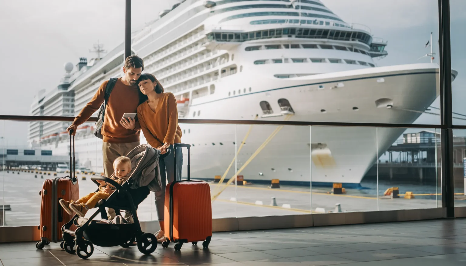 Familie mit Gepäck und Kinderwagen im Terminal vor Kreuzfahrtschiff
